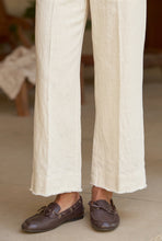 Load image into Gallery viewer, Close-up of cropped white wide-leg sweatpant trousers paired with brown leather loafers