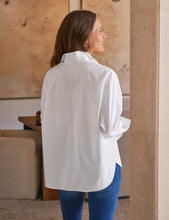 Load image into Gallery viewer, Model wearing oversized white button-up shirt with blue jeans, back view shown