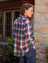Load image into Gallery viewer, Woman wearing a relaxed plaid flannel button-up shirt, shown from the back outdoors