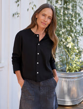 Load image into Gallery viewer, Woman wearing a black button-front cardigan blouse with white buttons and long sleeves