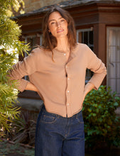 Load image into Gallery viewer, Woman wearing a button-front cardigan sweatshirt tucked into dark wash jeans outdoors