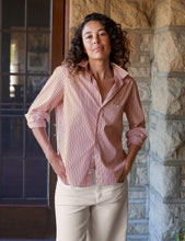 Load image into Gallery viewer, Woman wearing a relaxed striped button-up shirt with rolled sleeves and collar, styled with beige trousers