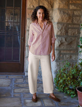 Load image into Gallery viewer, Model wearing a relaxed striped button-up shirt with rolled sleeves, paired with wide-leg trousers