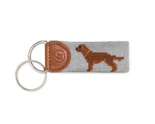 Load image into Gallery viewer, Needlepoint keychain featuring an embroidered golden retriever dog on gray fabric with leather tab and dual silver rings