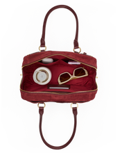 Load image into Gallery viewer, Overhead view of open Hammitt Meredith Medium bag showing interior compartments with sunglasses and accessories