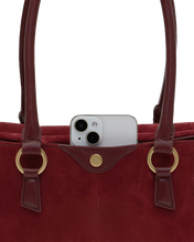 Load image into Gallery viewer, Close-up of a burgundy suede tote bag with an iPhone tucked into the exterior front pocket