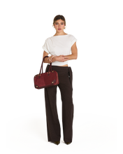 Load image into Gallery viewer, Model carrying Hammitt Meredith Medium satchel bag with gold hardware on forearm