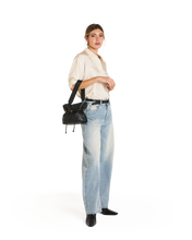 Load image into Gallery viewer, Model wearing light jeans carries small black leather drawstring bucket bag crossbody