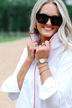 Load image into Gallery viewer, Model wearing white button-down shirt with red piping detail, styled with sunglasses and layered jewelry