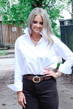 Load image into Gallery viewer, Woman wearing a white button-down shirt with ruffle collar, styled with dark jeans and brown belt