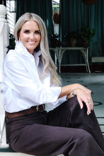 Load image into Gallery viewer, Woman seated on porch steps wearing white ruffle collar button-down shirt with dark trousers