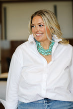 Load image into Gallery viewer, Woman wearing white ruffle collar button-down shirt with turquoise beaded necklace and jeans