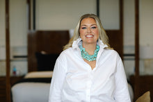 Load image into Gallery viewer, Woman wearing white ruffle collar button-down shirt styled with turquoise statement necklace, seated indoors