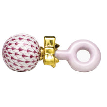 Load image into Gallery viewer, Herend porcelain baby rattle with raspberry fishnet pattern ball, gold bow, and pink ring handle