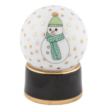 Load image into Gallery viewer, Herend porcelain snow globe figurine featuring hand-painted snowman with green hat and scarf on black base