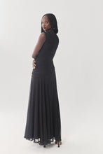 Load image into Gallery viewer, Model wearing a sleeveless black ruched maxi dress with flared skirt, back view