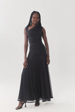 Load image into Gallery viewer, Model wearing a sleeveless ruched black maxi dress with asymmetric neckline and flowy skirt