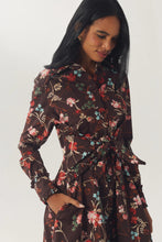 Load image into Gallery viewer, Model wearing a long-sleeve floral shirt dress with ruffle waist detail and side pockets