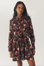 Load image into Gallery viewer, Model wearing long-sleeve brown floral mini shirtdress with tie waist and ruffle details