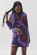 Load image into Gallery viewer, Model wearing a bold swirling patterned knit cardigan with gold buttons and matching mini skirt