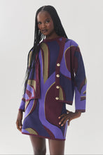 Load image into Gallery viewer, Model wearing a bold abstract-print knit cardigan and matching mini skirt set with gold buttons