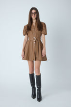 Load image into Gallery viewer, Model wearing a belted faux leather mini dress with puff sleeves and black knee-high boots