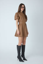 Load image into Gallery viewer, Model wearing a belted faux leather mini dress with puff sleeves and button-front detail