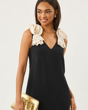 Load image into Gallery viewer, Model wearing a sleeveless black maxi dress with cream rosette shoulder straps and gold clutch