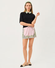 Load image into Gallery viewer, Model wearing black short-sleeve sweater with printed collar, styled with pink floral shorts