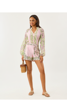 Load image into Gallery viewer, Model wearing long-sleeve paisley printed romper with tie waist and shorts, holding wicker bag