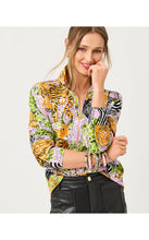 Load image into Gallery viewer, Model wearing a vibrant animal print zip-up pullover with tiger and zebra motifs