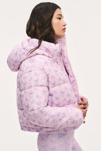 Load image into Gallery viewer, Model wearing a pink floral puffer jacket with hood, shown from side angle