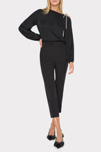 Load image into Gallery viewer, Model wearing black long-sleeve silk top with asymmetric neckline and delicate bow detail at shoulder