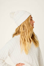 Load image into Gallery viewer, Model wearing a white cable-knit beanie with pom-pom, shown from side profile