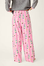 Load image into Gallery viewer, Back view of wide-leg pajama pants with champagne bottles and cupcakes print on pink stripes