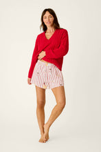 Load image into Gallery viewer, Model wearing striped holiday-print boxer shorts paired with a red cable-knit sweater