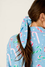 Load image into Gallery viewer, Back view of candy cane print blue pajama top with matching scrunchie hair accessory