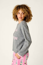 Load image into Gallery viewer, Model wearing a grey knit pullover sweater with pink script lettering, side view