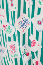 Load image into Gallery viewer, Close-up detail of mahjong tile print fabric with green and white stripes on pajama