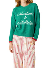 Load image into Gallery viewer, Model wearing green knit sweater with Martinis and Mistletoe script lettering paired with striped pants