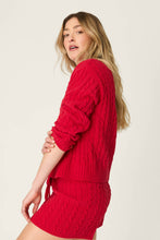Load image into Gallery viewer, Model wearing a red cable knit long sleeve sweater and matching shorts, side view