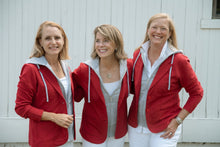 Load image into Gallery viewer, Three women wearing red hooded blazers smiling together outdoors against a white wall