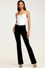 Load image into Gallery viewer, Model wearing black velvet flare pants with decorative buttons and white satin cami top