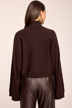 Load image into Gallery viewer, Back view of turtleneck sweater with wide sleeves paired with leather trousers