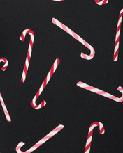 Load image into Gallery viewer, Close-up fabric detail of boxer briefs featuring red and pink candy cane pattern on black background