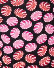 Load image into Gallery viewer, Close-up detail of swirling peppermint candy print fabric in pink, red, and white on black background