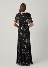 Load image into Gallery viewer, Back view of a floor-length black gown with gold floral sequin pattern and flutter sleeves