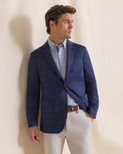 Load image into Gallery viewer, Man wearing a navy windowpane plaid blazer over a light blue shirt with white trousers