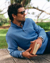 Load image into Gallery viewer, Man relaxing outdoors at picnic table wearing quilted quarter-snap pullover layered over plaid shirt