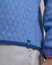 Load image into Gallery viewer, Close-up detail of quilted diamond-pattern pullover hem with Southern Tide logo tab and plaid sleeve cuff